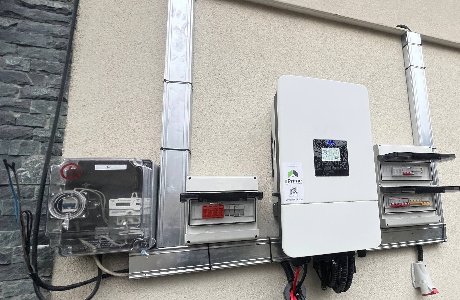 Invertor hibrid Deye și tablouri de protecție montate pe fațada casei.