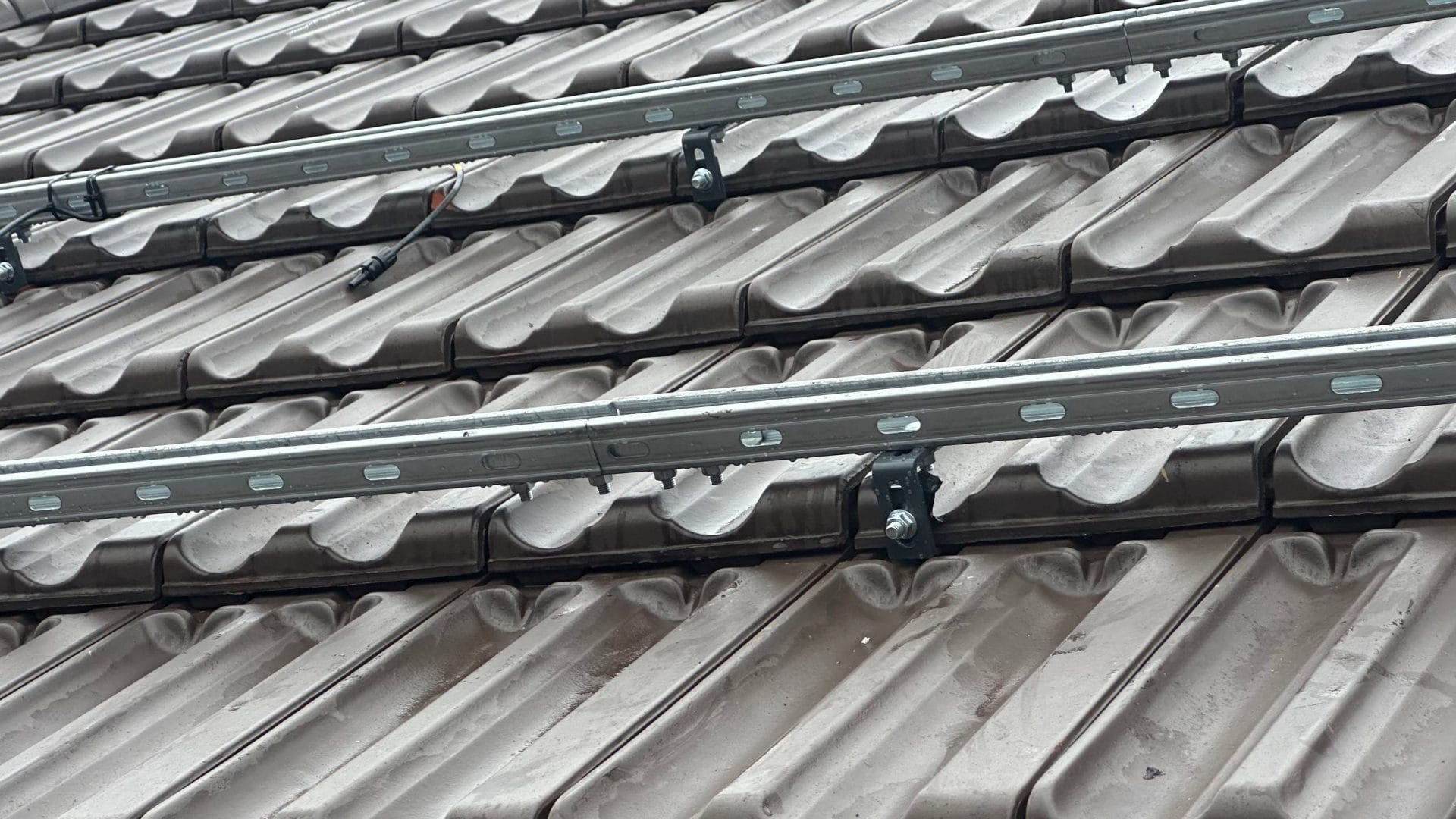 Detaliu structură de prindere panouri fotovoltaice pe acoperiș de țiglă.