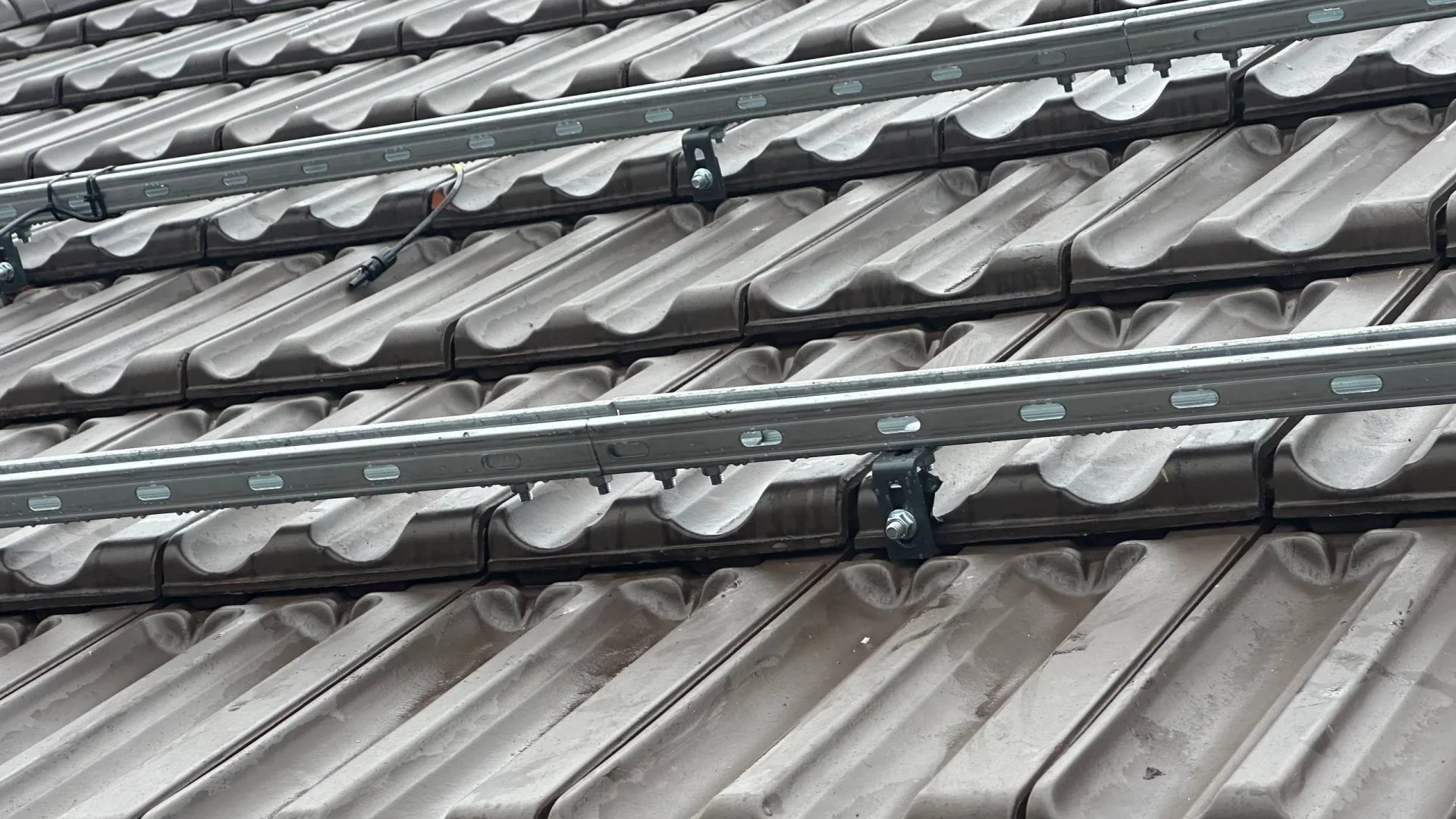 Detaliu structură de prindere panouri fotovoltaice pe acoperiș de țiglă.